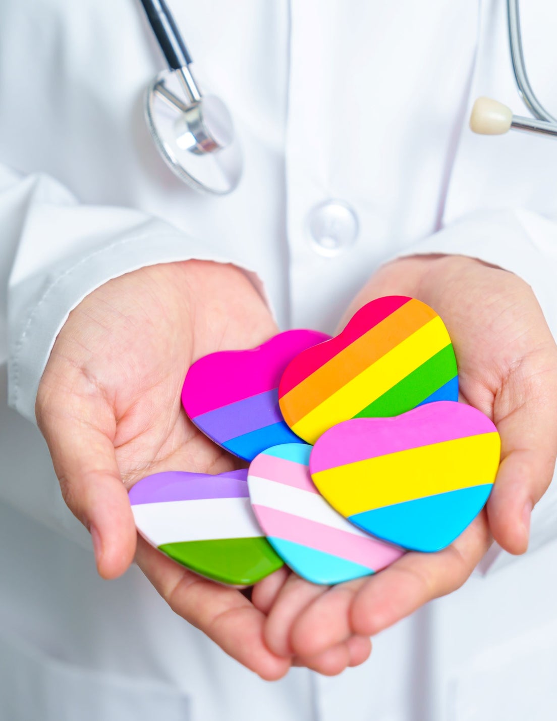 Doctor holding LGBTQ heart stickers